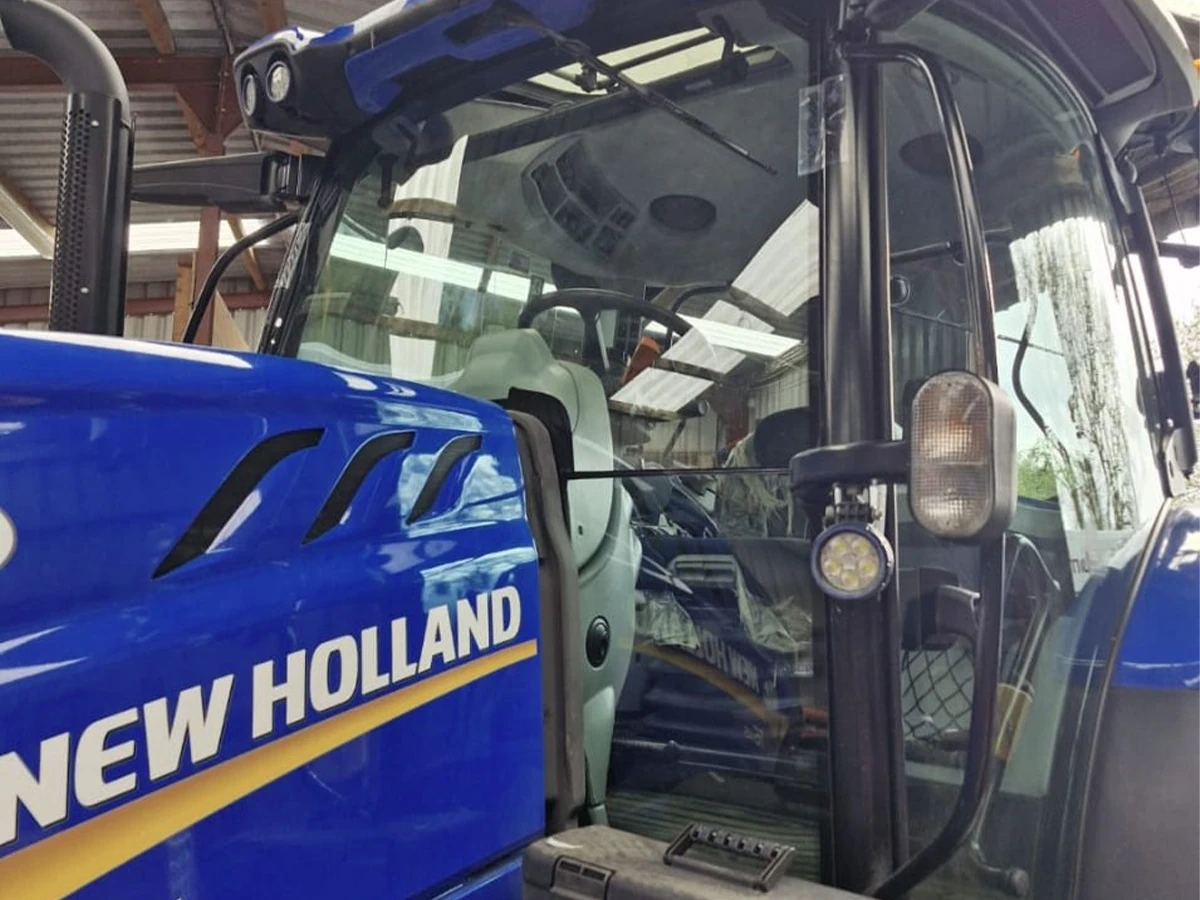 Close-up of a New Holland tractor cab door glass after fitting