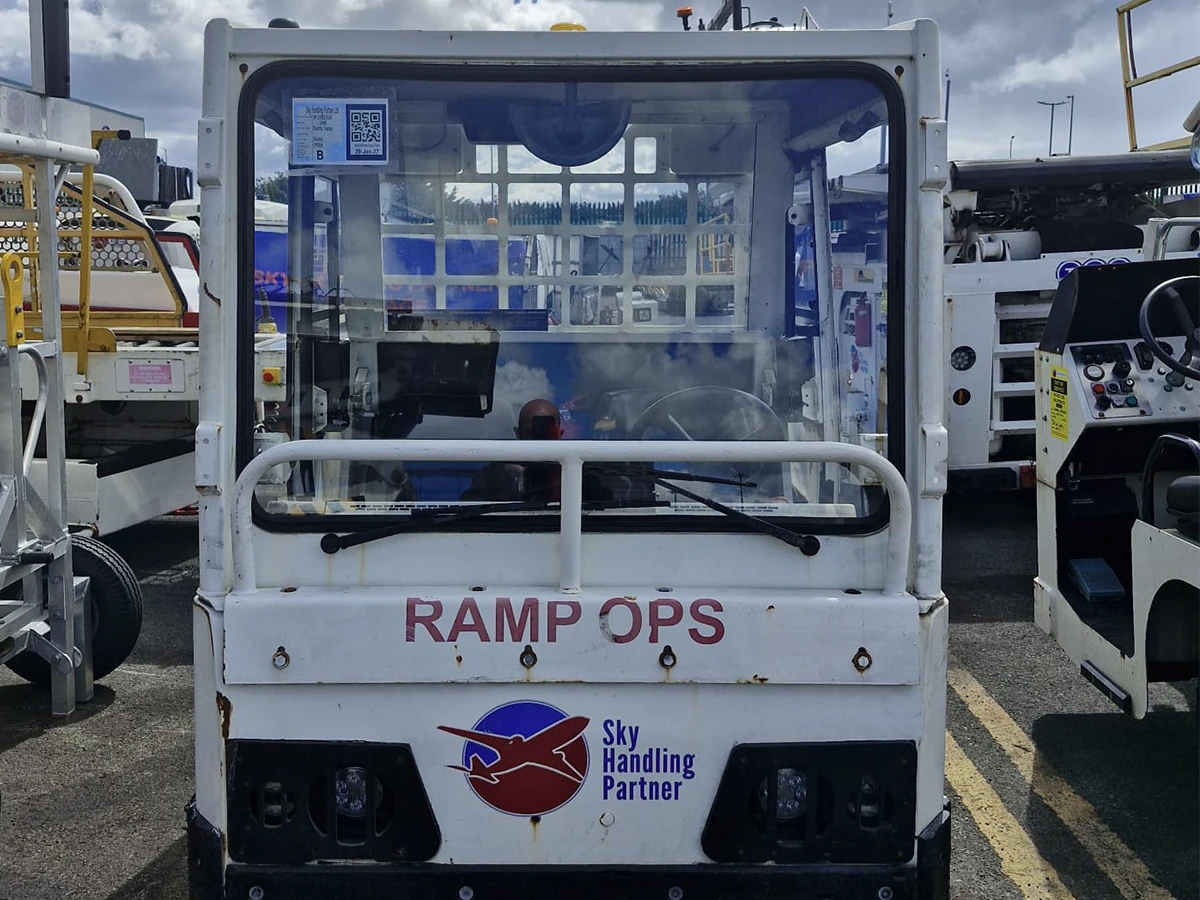 Airport baggage tug with a replacement windscreen on the apron