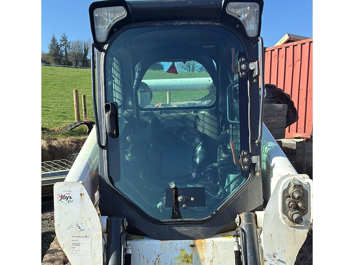 Bobcat skid-steer loader with newly fitted cab glass out in the yard