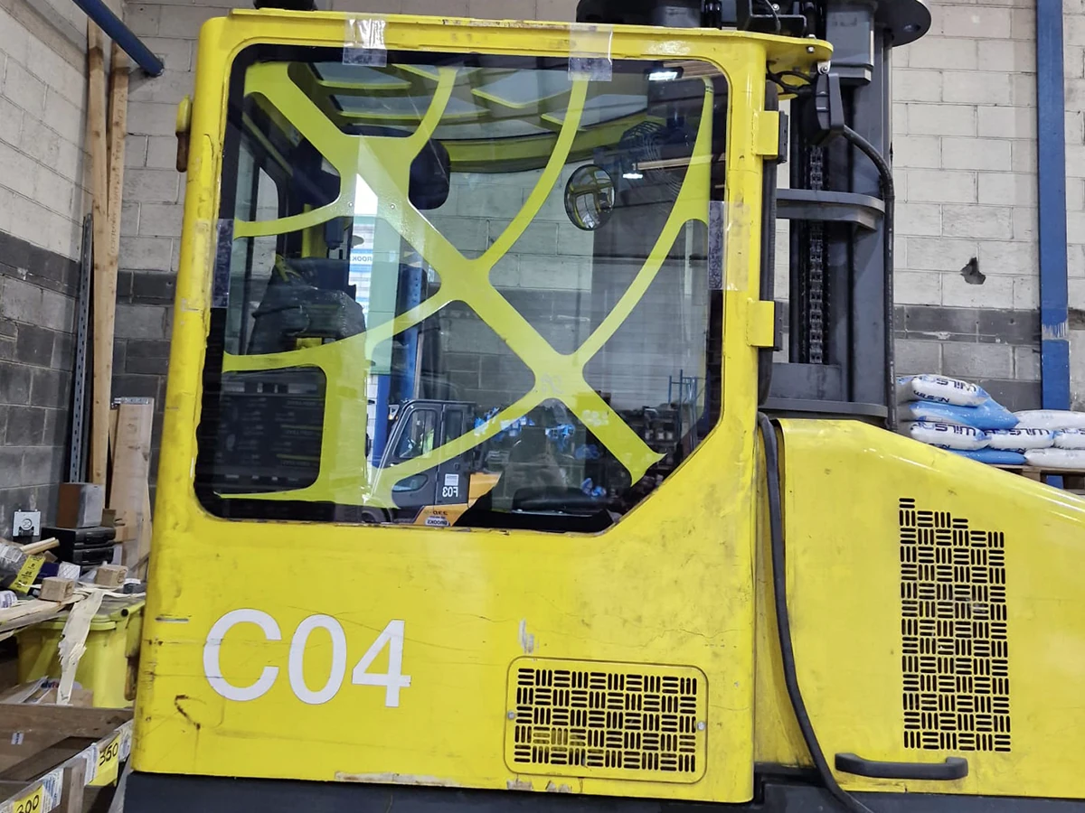 Industrial side-loading forklift with freshly fitted cab glass in the warehouse