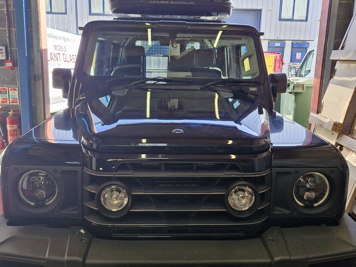 Black 4x4 off-roader with a replacement windscreen fitted in the workshop