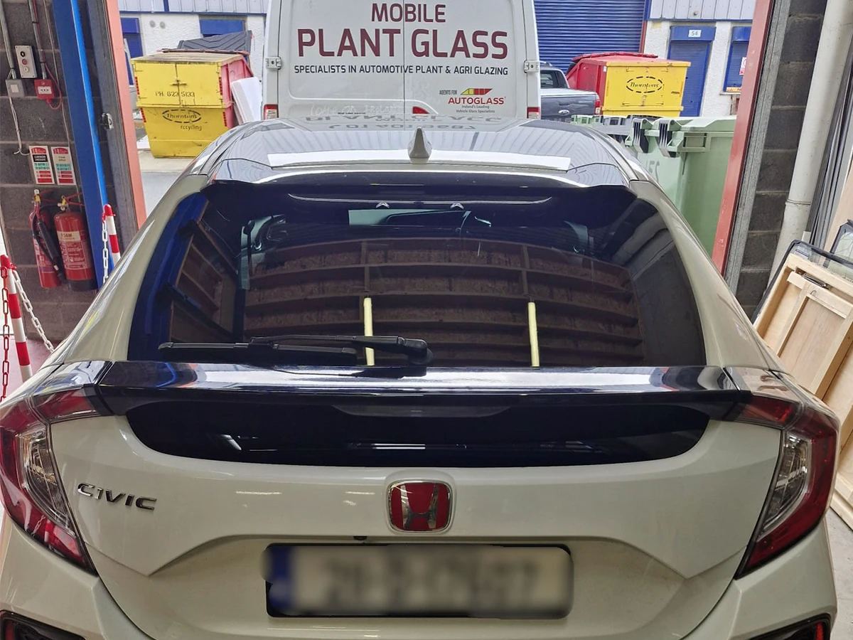 White Honda with a replacement rear windscreen at the workshop